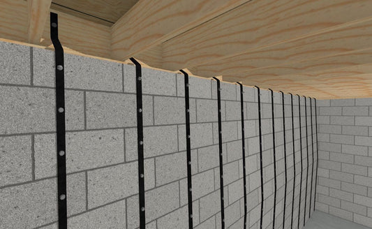 Basement Wall Straps fastened vertically to a concrete-block foundation wall beneath floor framing