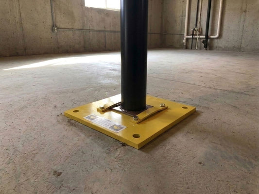 Nolan Insta-Footing with a wide steel lally column and flat retaining bars on an existing basement concrete slab