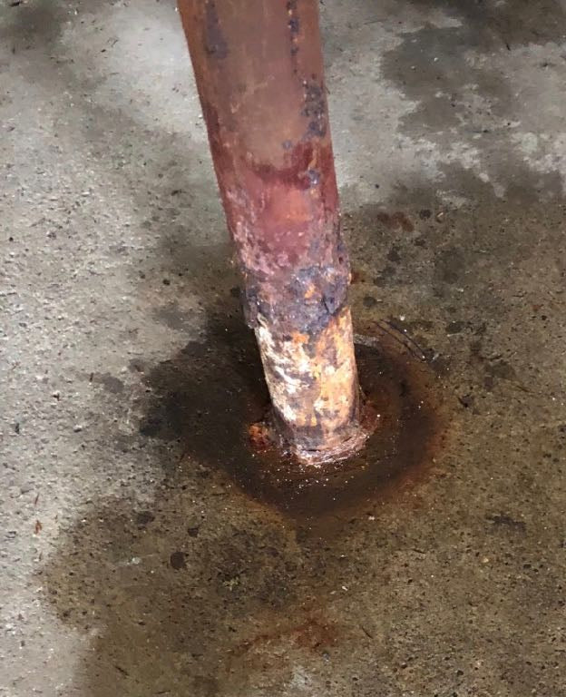 Rusted steel lally column requiring structural reinforcement