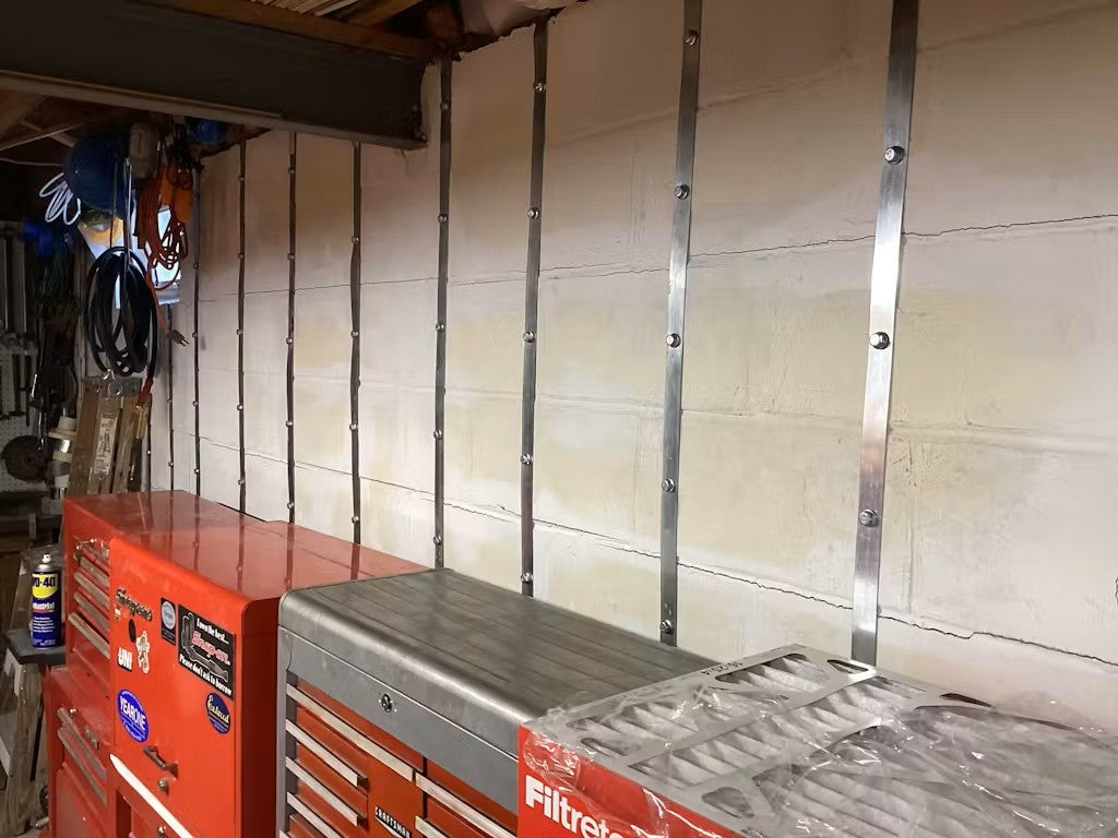 Multiple Nolan Basement Wall Straps installed on a concrete block foundation wall